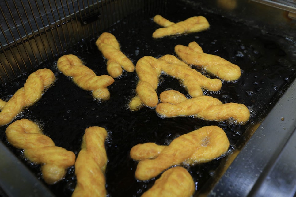 예쁘게 빚어낸 꽈배기를 기름에 튀긴 후 달달한 설탕가루를 솔솔 뿌려 묻혀주면 완성됩니다. 설탕을 뿌리지 않으면 쫄깃하고 담백한 맛이 매력이지만, 튀긴지 얼마 안 된 꽈배기에 달콤한 설탕가루까지 묻힌 뒤 먹으면 입안에 퍼지는 달콤함에 미소가 떠나지 않습니다.